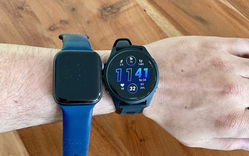 Die Garmin und die Apple Watch Seite an Seite auf dem Handgelenk
